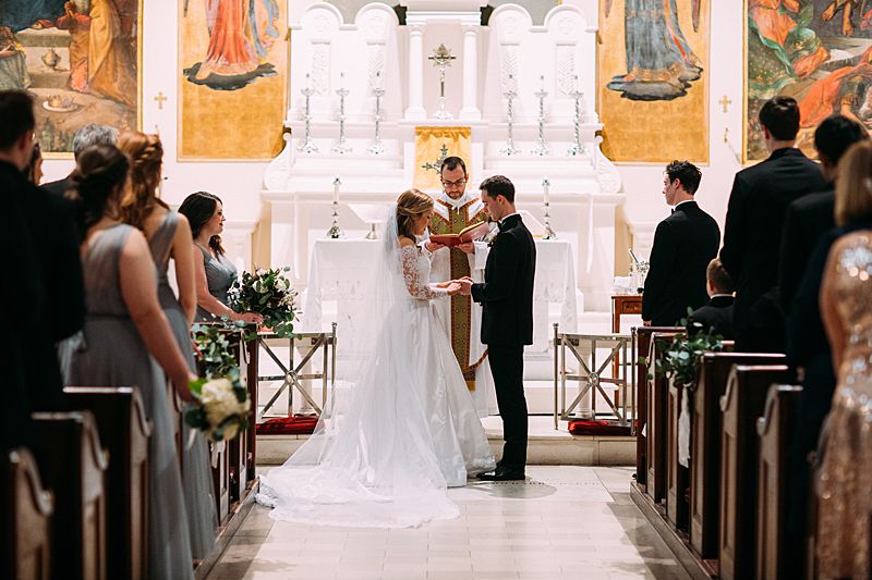 bride and groom at alter of st marys roman catholic church in downtown charleston for black tie february wedding