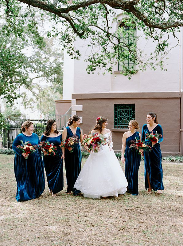 blue velvet bridesmaids dresses in charleston sc for fall wedding with bride holding jewel tone bouquet on kodak film